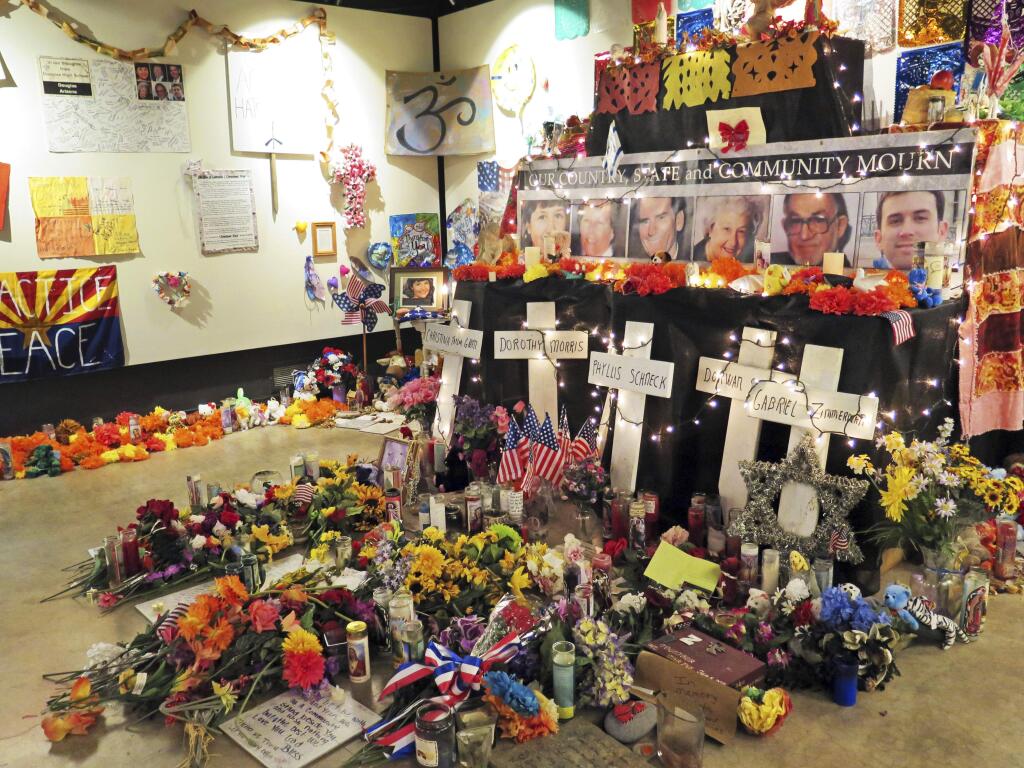 FILE - In this Jan. 9, 2015, file photo, flowers, teddy bears and inspirational posters line a room at the Arizona History Museum in Tucson, Ariz. The items were left at the scene of the Jan. 8, 2011, shooting in Tucson that left several dead and over a dozen wounded. Survivors of the Tucson mass shooting that left former U.S. Rep. Gabby Giffords severely wounded are pleading with the public to help pay for a long-planned memorial after state funding fell through during this year's Legislative session. (AP Photo/Astrid Galvan, File)