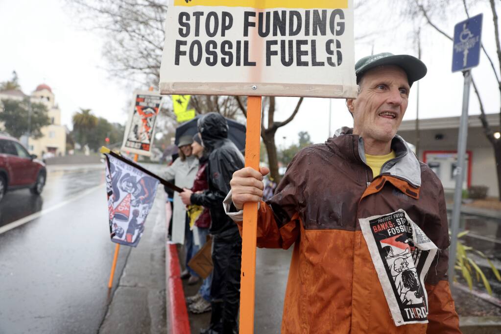Andy Bunnell joins protesters organized by Third Act as they gather outside Bank of America in Sebastopol, Tuesday, March 21, 2023. (Beth Schlanker / The Press Democrat)