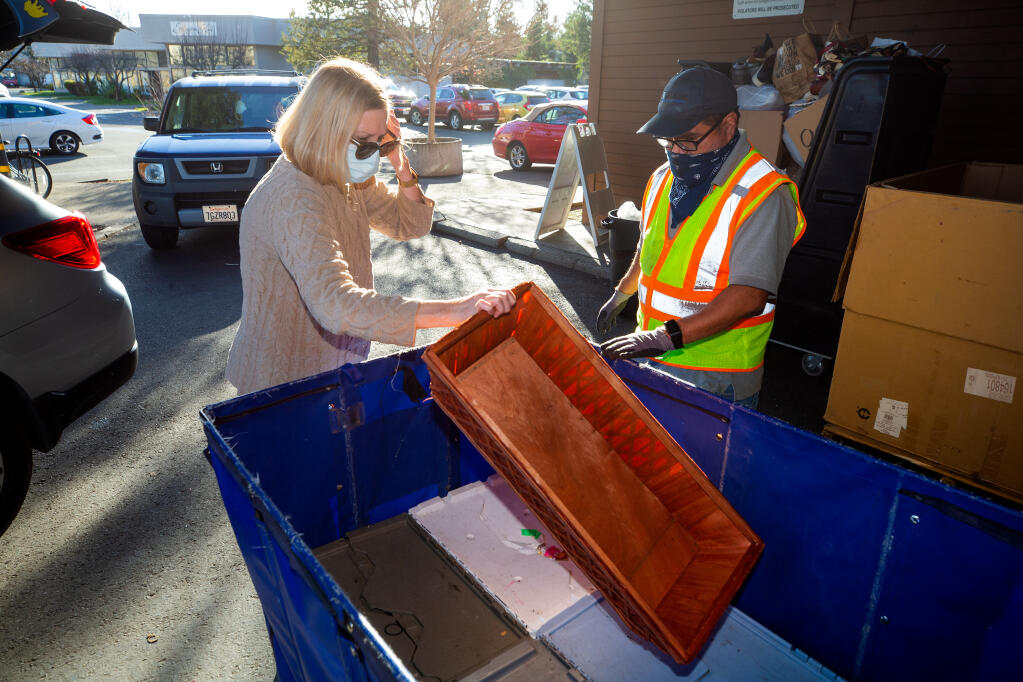 Barbara Polster drops off assorted housewares with assistance from Goodwill employee Jay Ledwick, during drive-thru donations at Goodwill in Santa Rosa on Friday, Jan. 8, 2021. (Alvin A.H. Jornada / The Press Democrat)