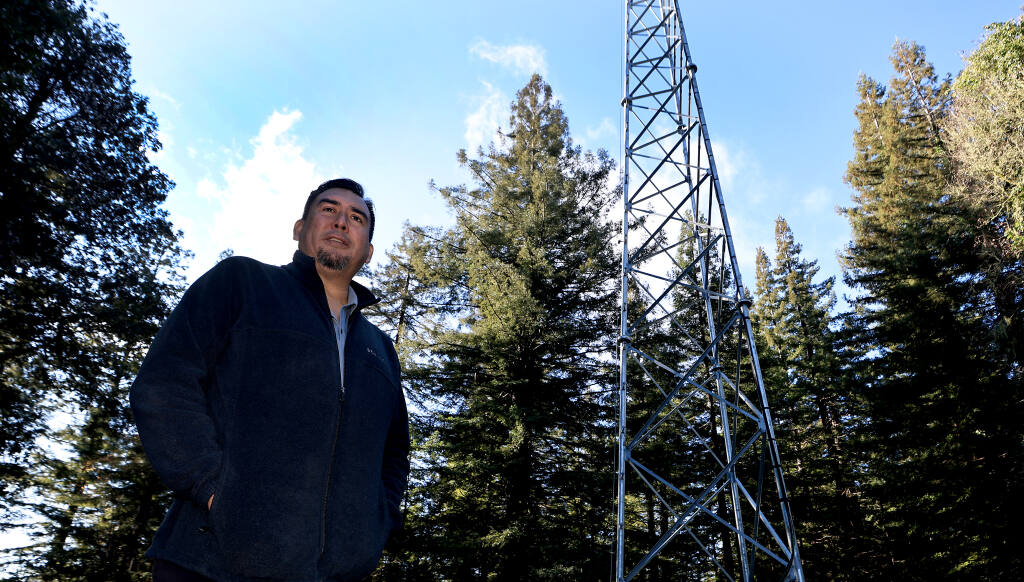 Vaughn Pena, the Kashia tribal administrator, with a A 200-foot tower recently installed for broadband reception, purchased with funds from the federal CARES Act at the Kashia Band of Pomo Indians community in the northwest corner of Sonoma County, Tuesday, Dec. 14, 2021. The antenna brings broadband service to about 70 residents. (Kent Porter/The Press Democrat)