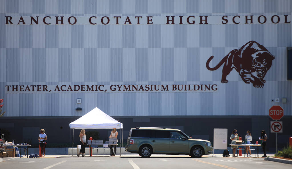 A drive-thru school supply pickup gets under way, Wednesday, Aug. 12, 2020 at Rancho Cotate High School in Rohnert Park.  (Kent Porter / The Press Democrat)