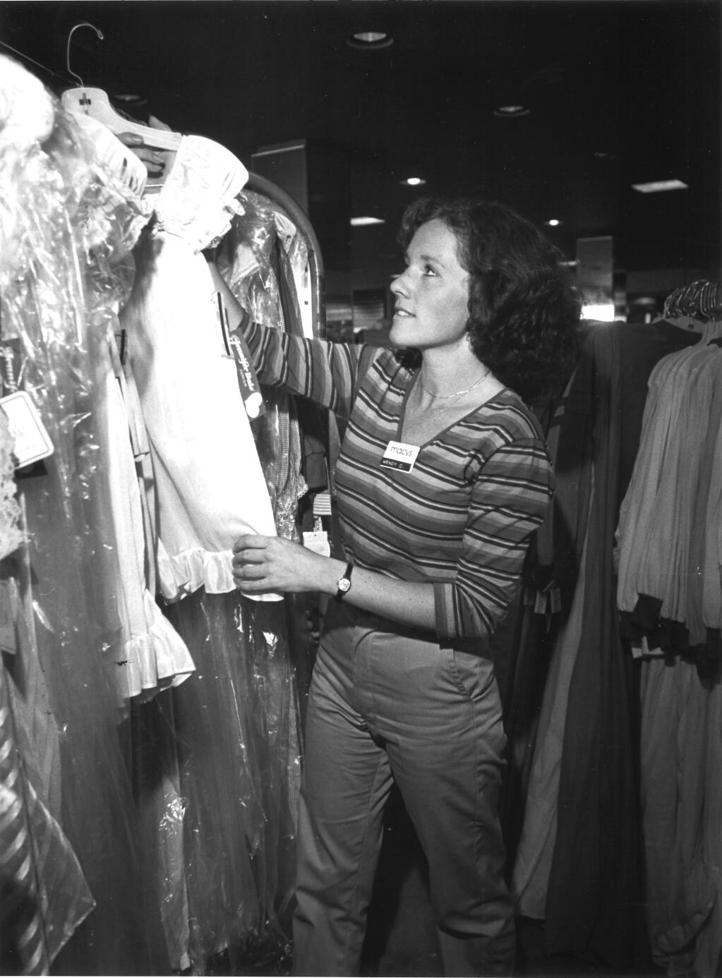 Wendy Cole, group sales manager, hangs up a clothing item at the Macy’s in the Santa Rosa Plaza in 1981. (The Press Democrat)