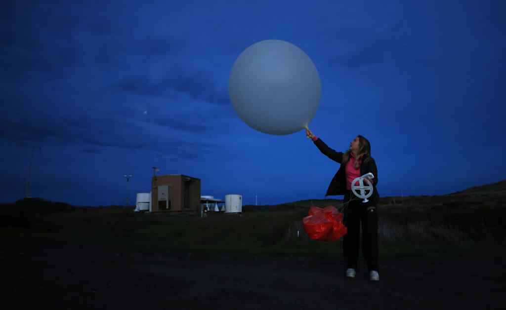 Jeri Wilcox, a field researcher for the Center for Western Weather and Water Extremes, prepares Saturday, Jan. 27, 2024, to release a weather balloon and accompanying radiosonde at the UC Davis-Bodega Marine Laboratory in Bodega Bay. Wilcox, along with her colleagues at the Scripps Institution of Oceanography at the University of San Diego are launching weather balloons every three hours to gather soundings of atmospheric rivers funneling over Northern California. (Kent Porter / The Press Democrat)