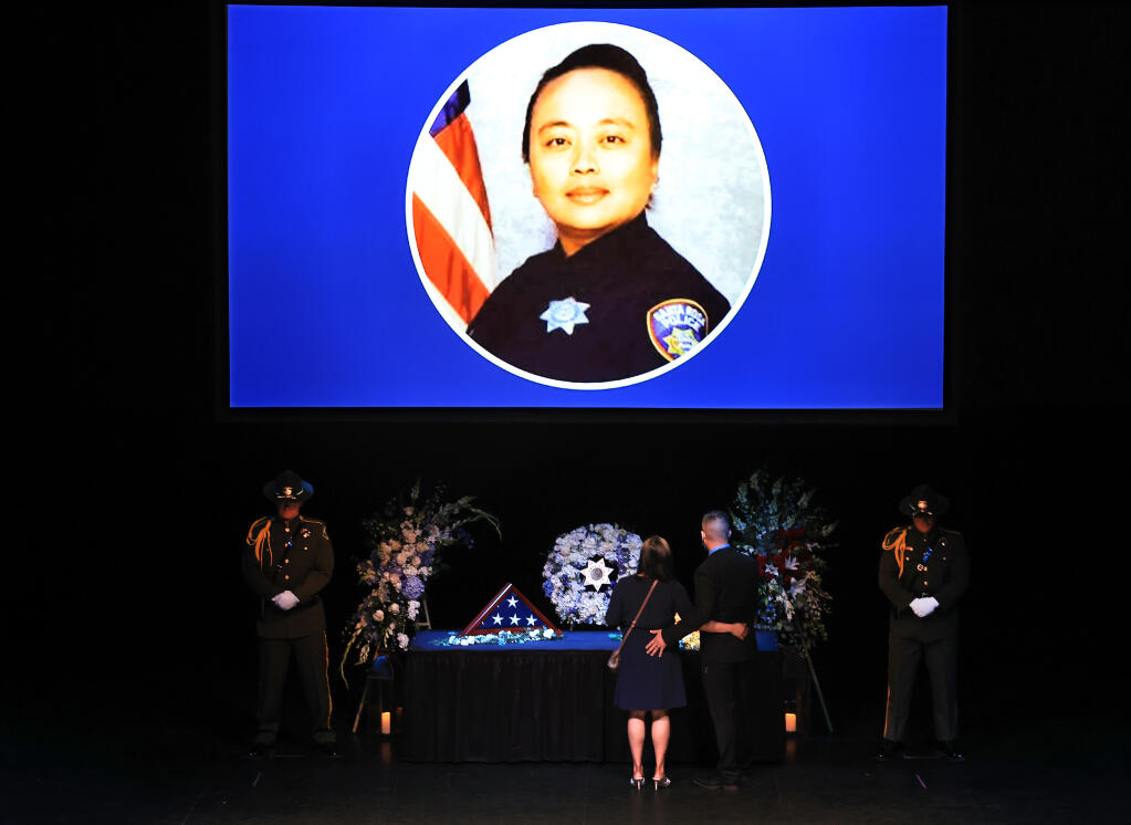 Family view a display for Marylou Armer, Thursday, July 8, 2021 during a memorial service at the Luther Burbank Center for the Arts, for the detective who died of COVID-19 in 2020. (Kent Porter / The Press Democrat) 2021