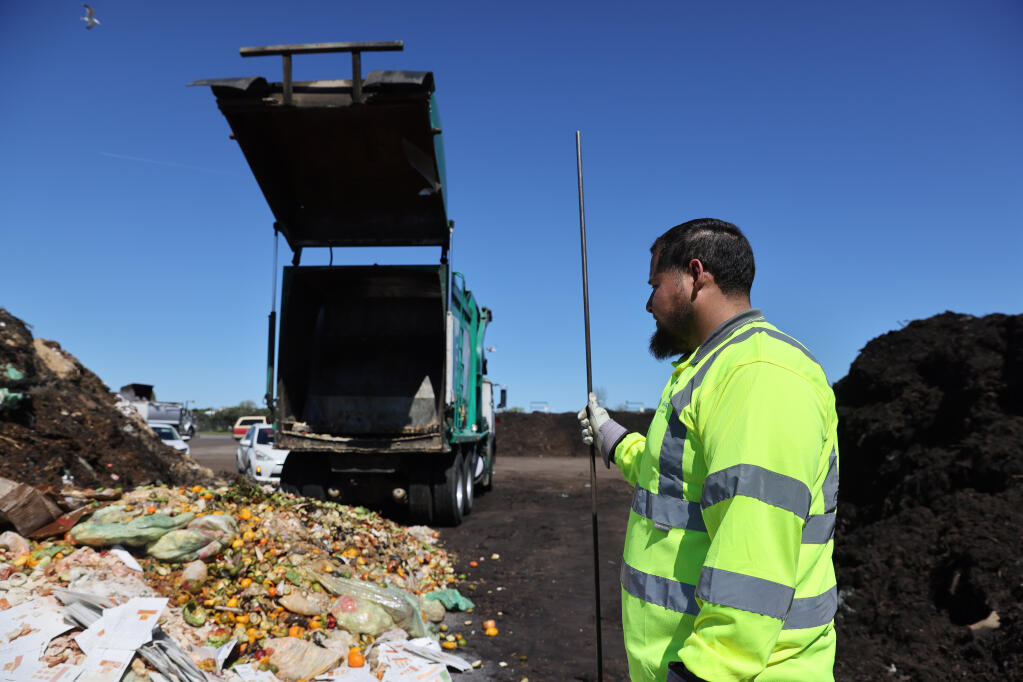 Recology driver Diego Hernandez surveys his load of organic material from commercial compost bins after unloading the truck at the Recology waste facility in American Canyon, Calif., on Tuesday, March 22, 2022.(Beth Schlanker/The Press Democrat)