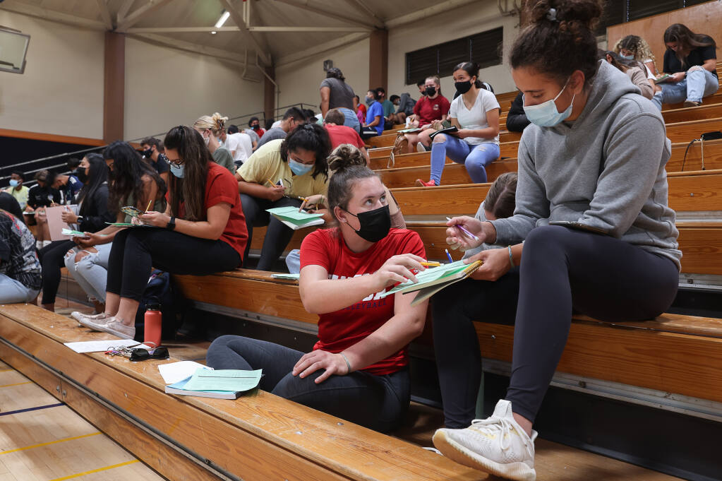 Santa Rosa Junior College volleyball players Destiny Clark, left, and Isa Ponce fill out their athletic eligibility forms in Haehl Pavilion in Santa Rosa on Wednesday, August 4, 2021.  (Christopher Chung/ The Press Democrat)