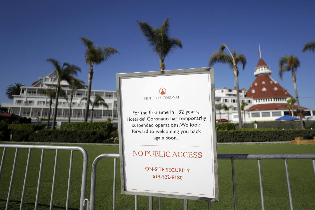 FILE - This June 11, 2020 file photo shows a sign is posted outside the Hotel Del Coronado in Coronado, Calif. California's unemployment rate has fallen to 11.4% in August. The Employment Development Department says the state added 101,900 jobs in August. Most of those were government jobs, including temporary positions for the U.S. Census. California lost more than 2.6 million jobs in March and April because of the coronavirus. (AP Photo/Gregory Bull, File)
