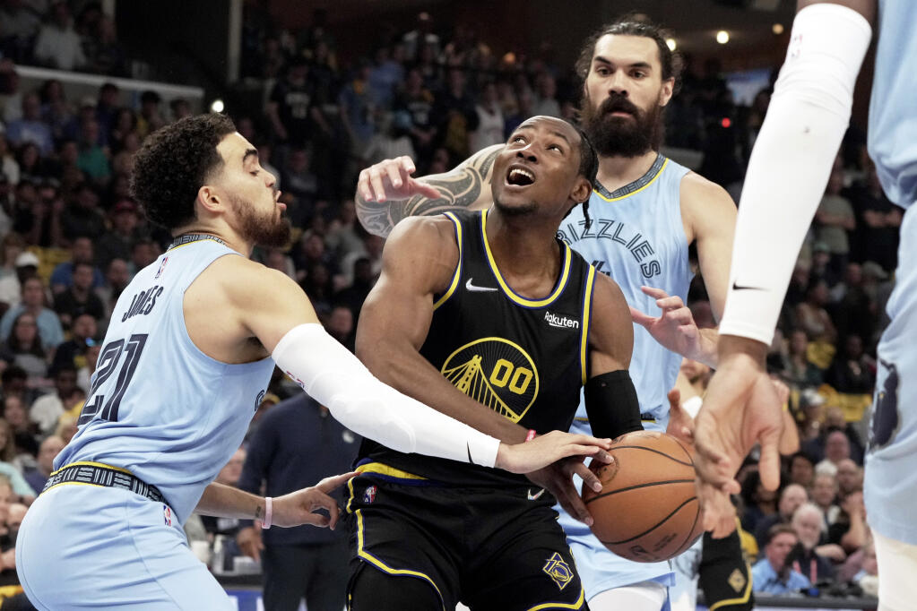 The Warriors' Jonathan Kuminga, center, goes up for a basket as the Grizzlies’ Tyus Jones defends in the first half of Game 5 of a second-round playoff series Wednesday, May 11, 2022, in Memphis, Tennessee. (Karen Pulfer Focht / ASSOCIATED PRESS)