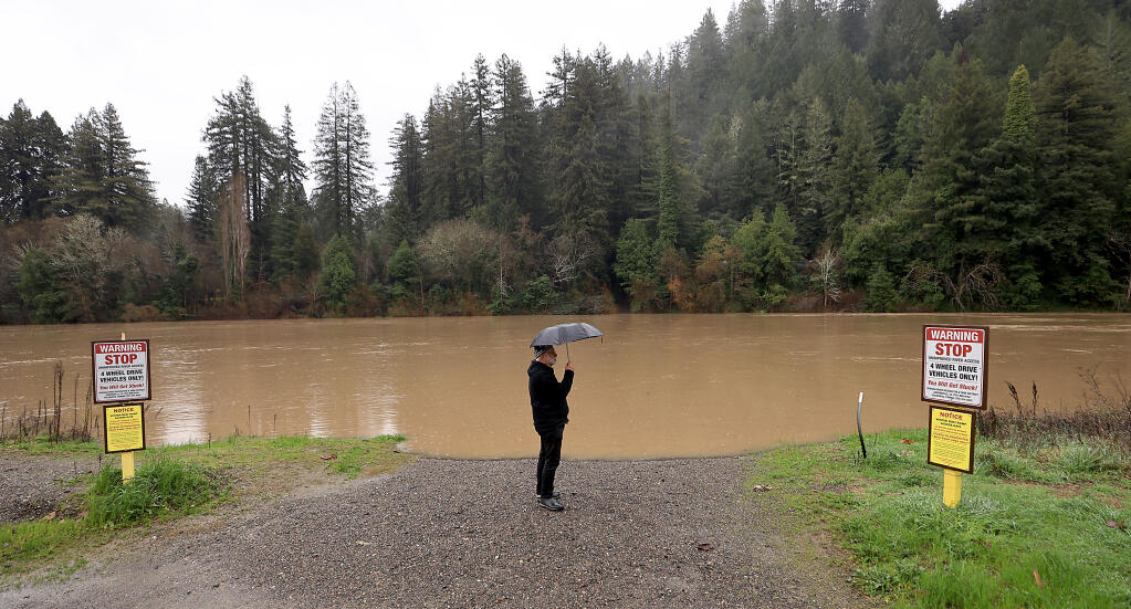 Pete Shaw of Guerneville gets his take on the level of the Russian River, Thursday, Jan. 5, 2023 at Johnson's Beach. (Kent Porter / The Press Democrat) 2023
