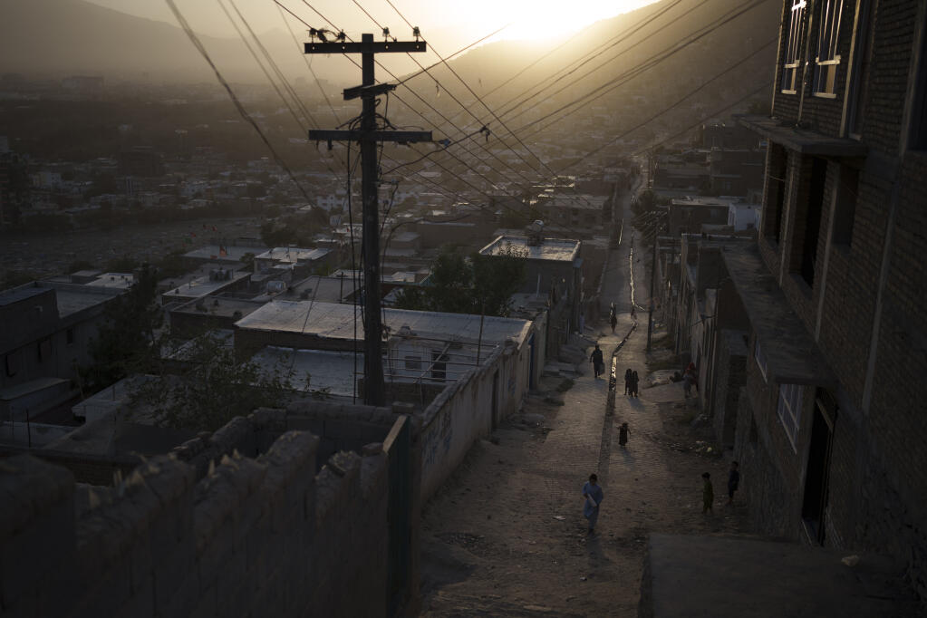 People walk through an alleyway as the sun sets in Kabul, Afghanistan, Thursday, Sept. 16, 2021. (AP Photo/Felipe Dana)