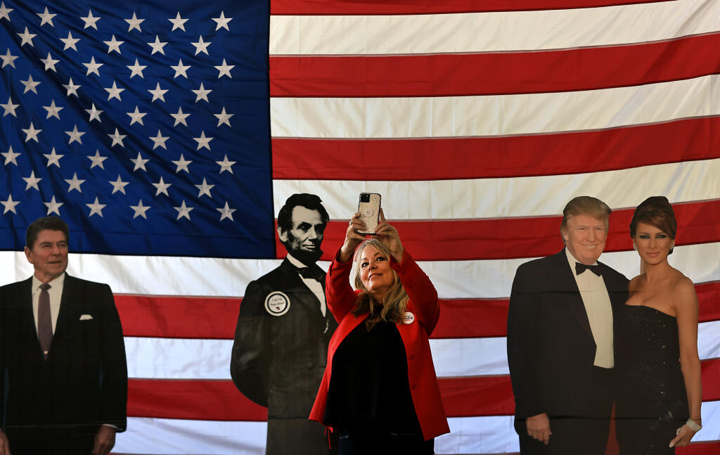 Karen Boyd of Bakersfield makes a selfie with life-size cutouts of Ronald Reagan, Abraham Lincoln and the Trumps, during the Sonoma County Republican Convention, Saturday, August 26, 2023 at the Sonoma County Fairgrounds in Santa Rosa. (Kent Porter / The Press Democrat) 2023