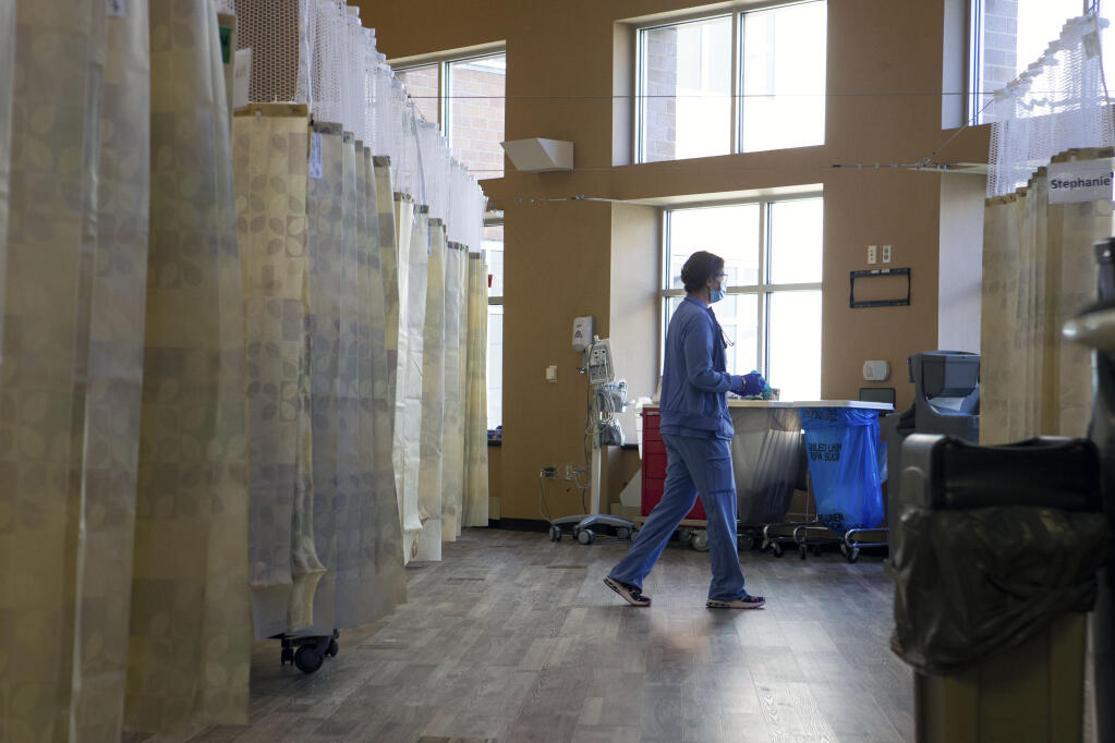 Staff members monitor patients in a corridor of Stormont Vail Health converted into hospital rooms Wednesday afternoon as an influx of COVID-19 patients filled portions of the hospital. [Evert Nelson/The Capital-Journal via AP]