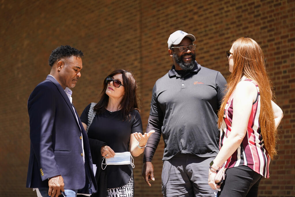 From left, former NFL player Ken Jenkins and his wife, Amy Lewis, along with former player Clarence Vaughn III and his wife, Brooke Vaughn, meet in May 2021 outside the federal courthouse in Philadelphia. (Matt Rourke / ASSOCIATED PRESS)