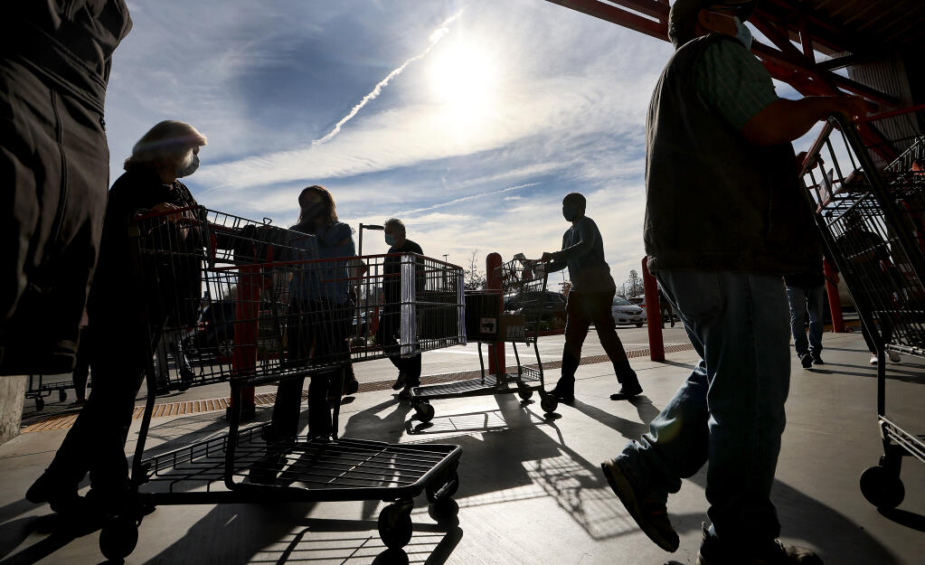 Shoppers head in and out of Costco in Santa Rosa, Tuesday, Jan. 11, 2021, in what one employee, who didn't want to be identified, said “was a pretty normal day.” The latest guidelines will go in to effect at 12:01 a.m. Wednesday in response to the rapid spread of the COVID-19 omicron variant. (Kent Porter / The Press Democrat)