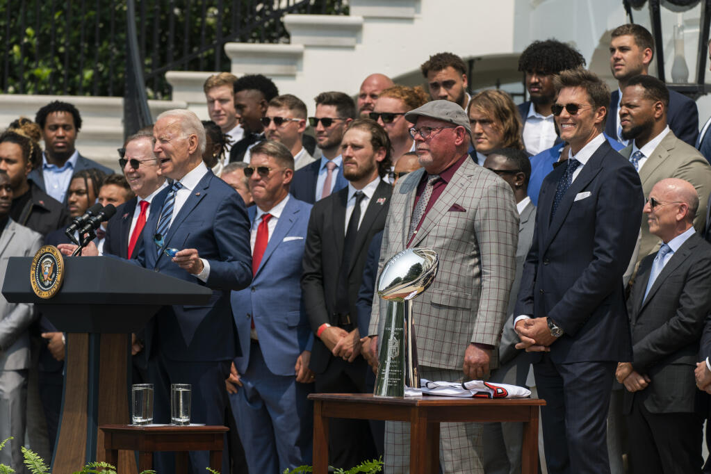 President Joe Biden, surrounded by members of the Tampa Bay Buccaneers including Tom Brady, right, speaks during a ceremony on the South Lawn of the White House, in Washington, Tuesday, July 20, 2021, where the president honored the Super Bowl Champion Tampa Bay Buccaneers for their Super Bowl LV victory. (AP Photo/Manuel Balce Ceneta)