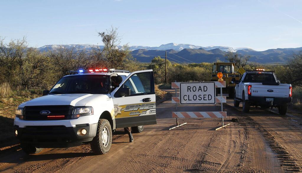 This Saturday, Nov. 30, 2019, photo shows the road closed near Bar X road and Tonto Creek after a vehicle was washed by flood waters in Tonto Basin, Ariz. Rescuers with helicopters, drones, boats and dogs searched Sunday for a 6-year-old girl missing since Friday, when a truck she was in was swept away while attempting to cross an Arizona creek swollen by runoff from a powerful storm. (Patrick Breen/The Arizona Republic via AP)
