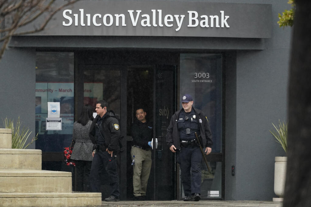 Santa Clara Police officers exit Silicon Valley Bank in Santa Clara, Calif., Friday, March 10, 2023. The Federal Deposit Insurance Corporation is seizing the assets of Silicon Valley Bank, marking the largest bank failure since Washington Mutual during the height of the 2008 financial crisis. The FDIC ordered the closure of Silicon Valley Bank and immediately took position of all deposits at the bank Friday.  (AP Photo/Jeff Chiu)