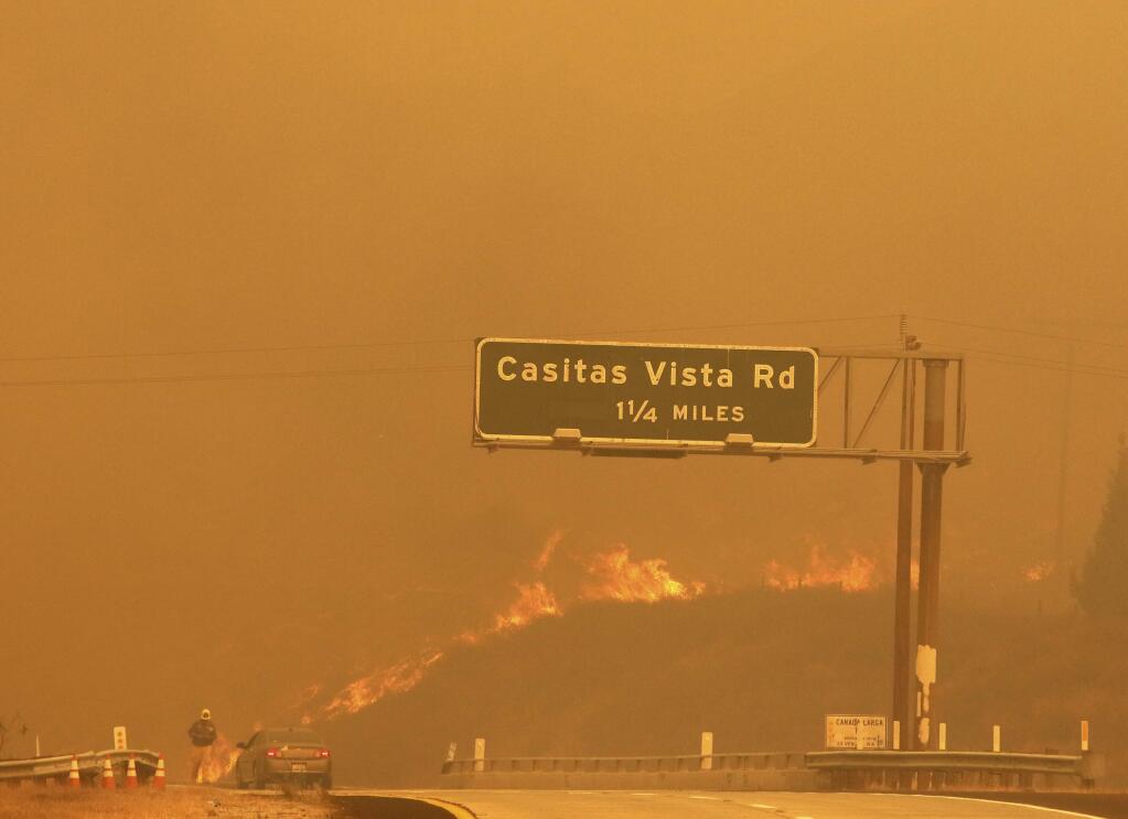 Flames and smoke shroud State Route 33 as a wildfire burns in Ventura, Calif., Tuesday, Dec. 5, 2017. (Daniel Dreifuss via AP)
