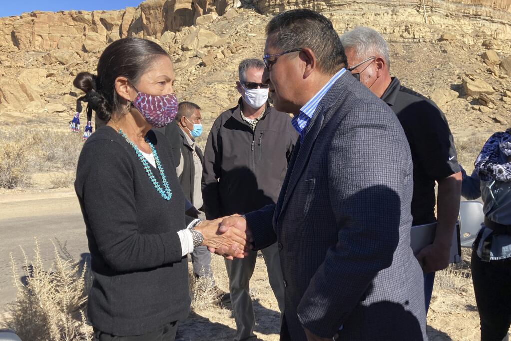 This Nov. 22, 2021 image shows former Hopi Vice Chairman Clark Tenakhongva, right, talking with U.S. Interior Secretary Deb Haaland after a celebration at Chaco Culture National Historical Park in northwestern New Mexico. Some tribes in the Southwest applauded Haaland's announcement that her agency was beginning the process to withdrawal federal land holdings near the park from oil and gas development for 20 years. (AP Photo/Susan Montoya Bryan)