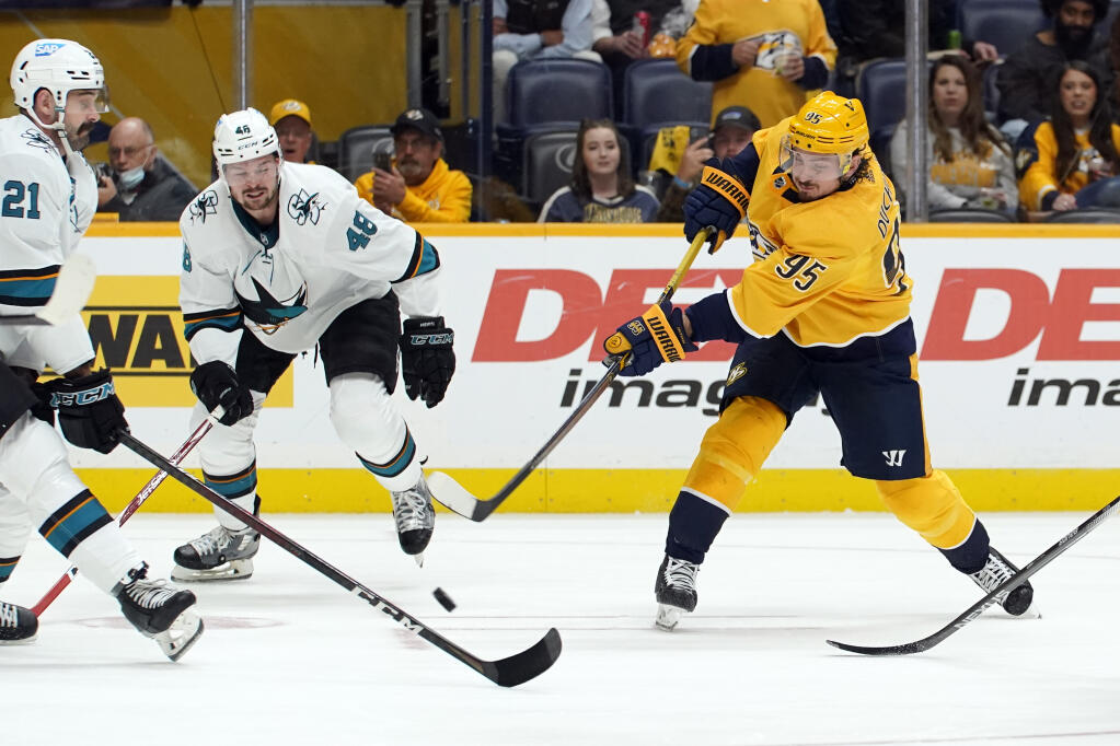 Nashville Predators center Matt Duchene (95) shoots as he is defended by San Jose Sharks' Jacob Middleton (21) and Tomas Hertl (48) in the second period of an NHL hockey game Tuesday, Oct. 26, 2021, in Nashville, Tenn. (AP Photo/Mark Humphrey)