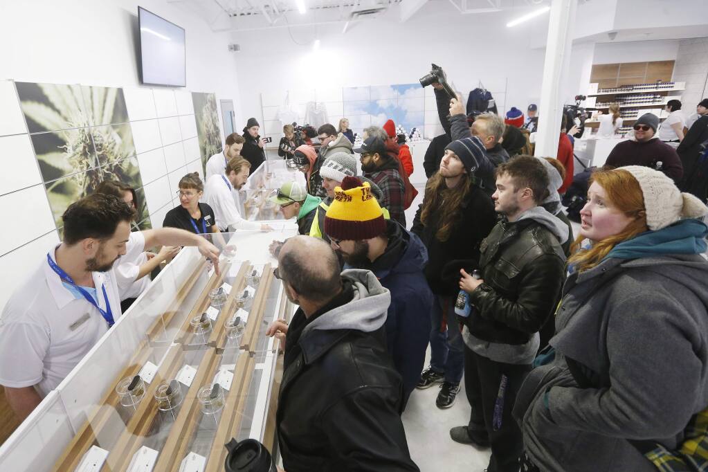 FILE - In this Oct. 17, 2018, file photo, people check out the sample counter at a cannabis store in Winnipeg, Manitoba. Supply shortages have been rampant in the two weeks since Canada became the largest national pot marketplace. (John Woods/The Canadian Press via AP, File)