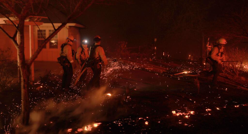 Firefighters prevent the spread of embers at a house fire on Chalk Hill Road, due to the Kincade fire blowing up with the wind, Sunday, October 27, 2019. (Kent Porter / The Press Democrat)