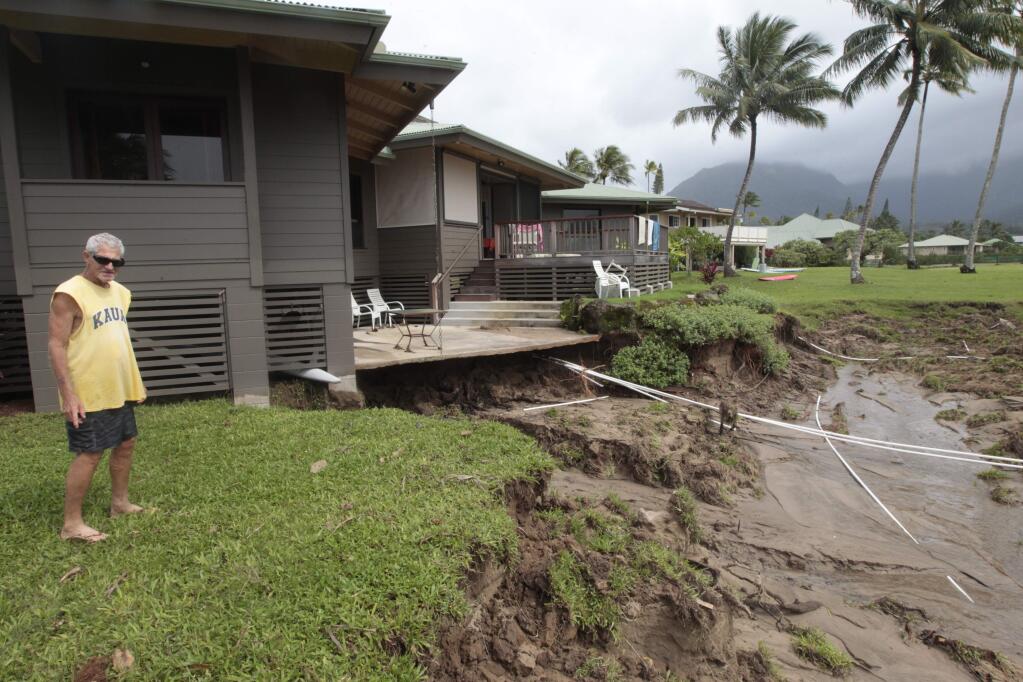 Richard Morris looks at the flood damage to his sister's home on Monday, April 16, 2018, in Hanalei, Kauai. Heavy rain and flooding caused extensive damage to both the north and south parts of the island. (Jamm Aquino/Honolulu Star-Advertiser via AP)