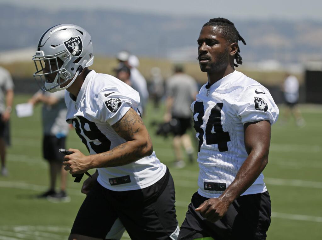 Oakland Raiders wide receivers Keelan Doss, left, and Antonio Brown warm up during minicamp Tuesday, June 11, 2019, in Alameda. (AP Photo/Eric Risberg)