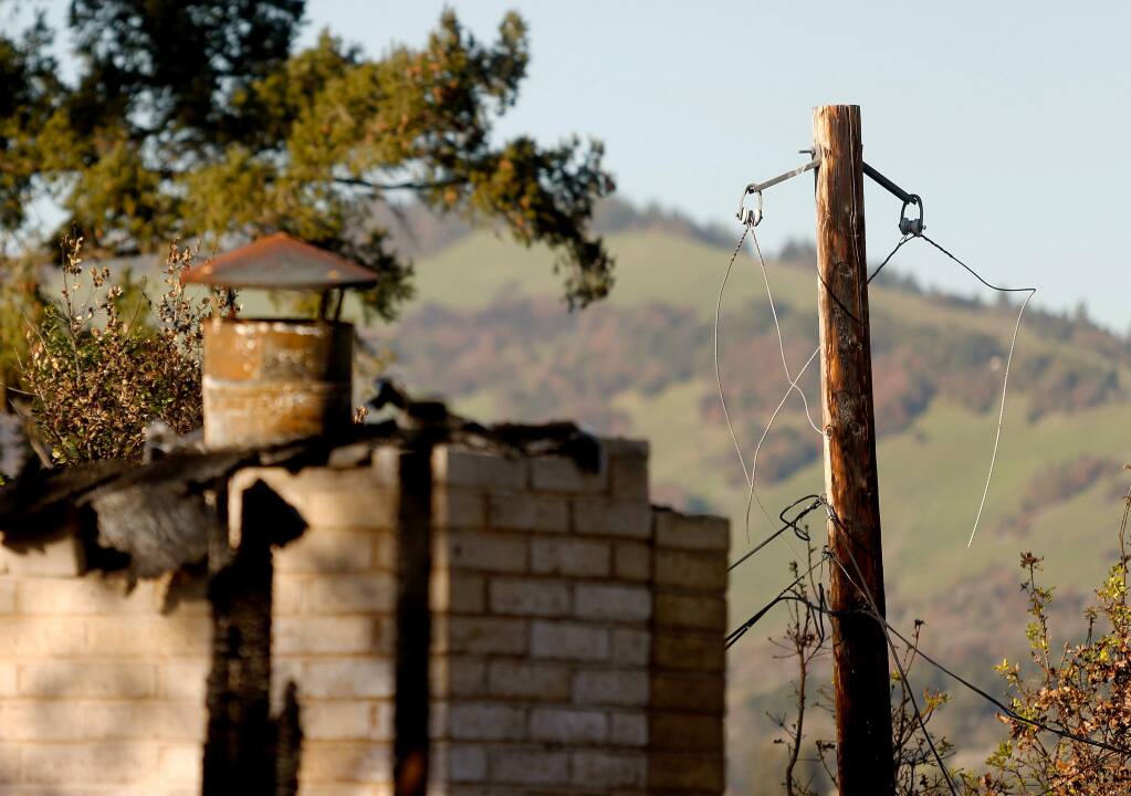 A burned utility pole, at right, still stands in front of the house Sam and Kathi Flores rented on Sullivan Way in Santa Rosa on Friday, Feb. 2, 2018. While the Flores's home burned down the same night as the Tubbs fire, Santa Rosa fire investigators determined that PG&E power lines impacted by heavy winds ignited the flames that burned their house down. (ALVIN JORNADA/ PD)