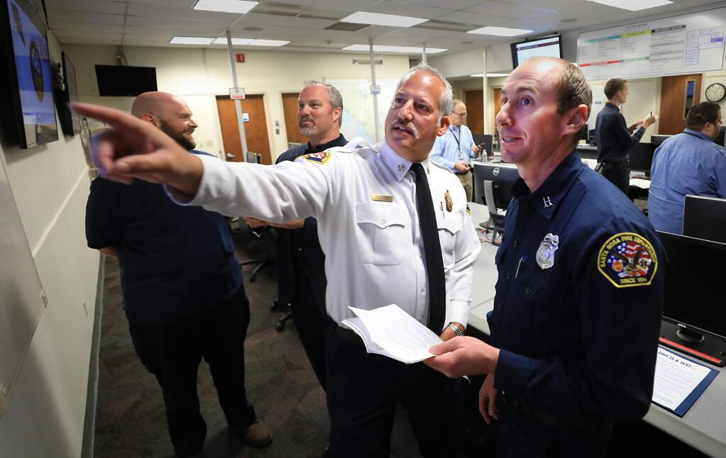 At the county center in Santa Rosa, Santa Rosa Fire Chief Tony Gossner and Santa Rosa Fire Department Assistant Fire Marshal Paul Lowenthal, watch as responses come in from the public, Wednesday, Sept. 12, 2018, as five target locations using the federal Wireless Emergency Alerts system were tested. Background from left are Neil Bregman, Santa Rosa's emergency preparedness coordinator and District 4 Supervisor James Gore. (Kent Porter / The Press Democrat)