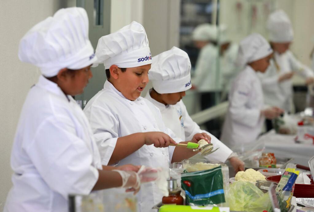 From left, Jasmine Lopez, Joseph Harris and Cristian Henriquez compete in the finals of the Sodexo Future Chefs Challenge at Lawrence E. Jones Middle School on Wednesday. Ten student chefs made the final round with their healthy comfort food recipes. (John Burgess/The Press Democrat)