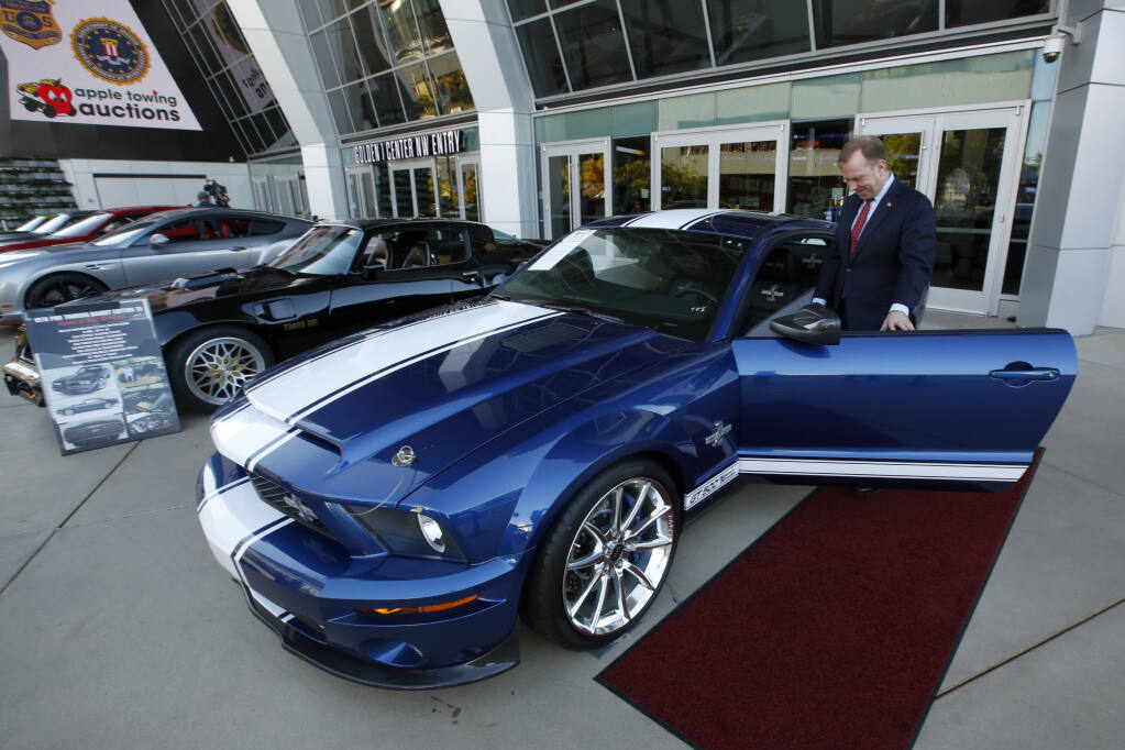 FILE - In this Oct. 23, 2019, file photo, McGregor Scott, who was then the U.S. Attorney for the Eastern District of California, looks over a 2007 Ford Shelby GT500 displayed in Sacramento, Calif., that was among the vehicles seized by the federal government to be auctioned off. The cars belonged to Jeff and Paulette Carpoff, owners of a San Francisco Bay Area solar energy company that pleaded guilty for participating in what federal prosecutors called a massive Ponzi scheme that defrauded investors of $1 billion. Jeff Carpoff, 50, was sentenced to 30 years in federal prison Tuesday, Nov. 9, 2021. (AP Photo/Rich Pedroncelli, File)