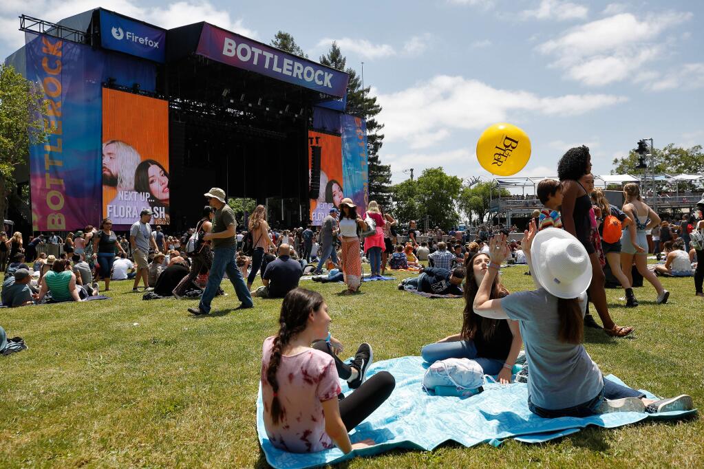 Beth Aguirre, right, of San Diego, and her daughters Hannah, 12, and Miriam, 12, play with a beach ball while waiting for Flora Cash to perform on the Firefox Stage at BottleRock Napa Valley, in Napa, California, on Friday, May 24, 2019. (Alvin Jornada / The Press Democrat)