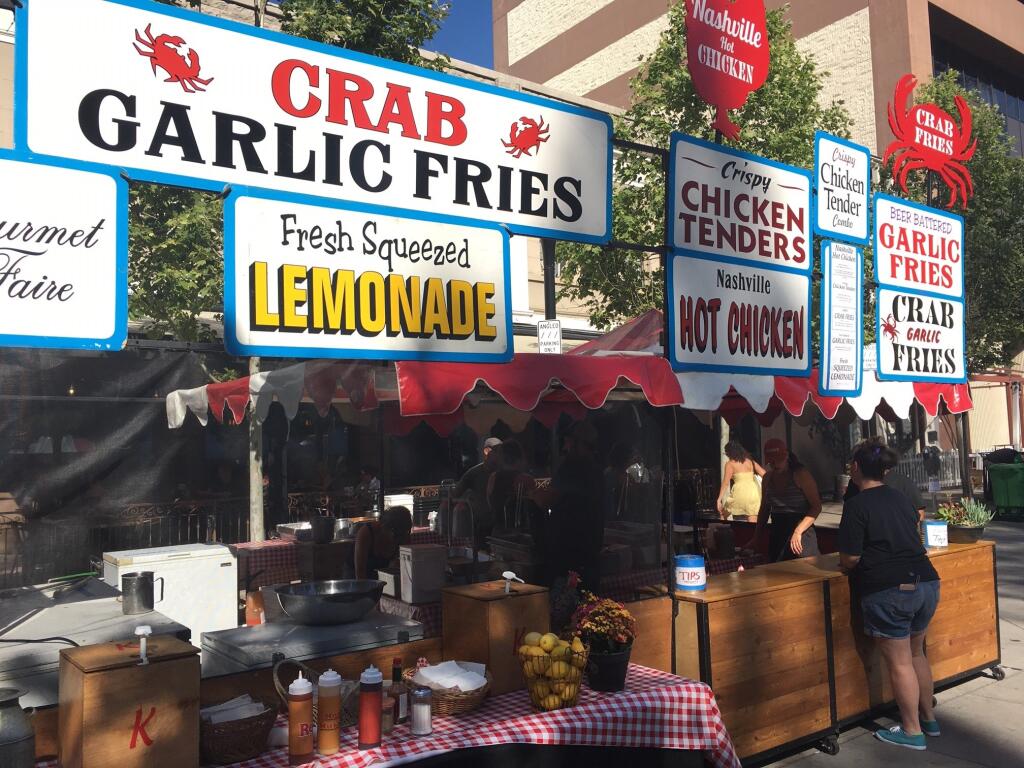 Gourmet Faire prepares to sell everything from Nashville Hot Chicken to Crab Garlic Fries at the Wednesday Night Market in downtown Santa Rosa on May 18, 2022. (Charlie Swanson / Press Democrat)