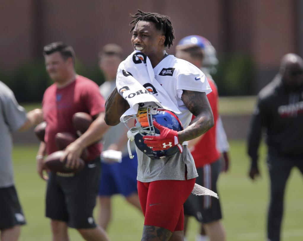 FILE - In this June 13, 2017, file photo, New York Giants' Brandon Marshall wipes away sweat during NFL football practice in East Rutherford, N.J. Marshall said it takes the entire offense working in sync to pull off the fake properly, from the running back going full speed as if he's getting the ball to the quarterback hiding the ball. Marshall said former teammate Peyton Manning was the best he's seen at that. (AP Photo/Seth Wenig, File)
