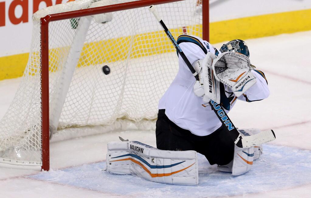San Jose Sharks goaltender Antti Niemi fails to block the puck as Winnipeg Jets' Andrew Ladd scores during first period action in Winnipeg, Manitoba, Tuesday, March 17, 2015. (AP Photo/The Canadian Press, Trevor Hagan)