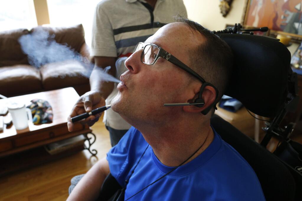 In this Aug. 21, 2015 photo, multiple sclerosis patient and author of the memoir 'One day at a Time,' David Sloan, who is a medical marijuana patient, exhales smoke from medical cannabis concentrate given to him with help from his caregiver, at Sloan's home in Highlands Ranch, south of Denver. Marijuana researchers have predominantly looked at how the drug affects young, developing brains. But increased pot use by older adults has scientists calling for more study of how aging influences drug use, and whether elderly pot users face potential health benefits or risks. (AP Photo/Brennan Linsley)