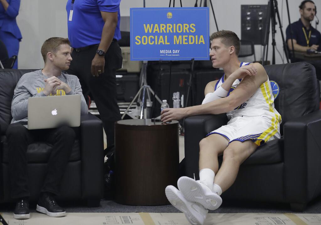 The Golden State Warriors' Jonas Jerebko, right, is shown during media day at the team's practice facility in Oakland, Monday, Sept. 24, 2018. (AP Photo/Jeff Chiu)