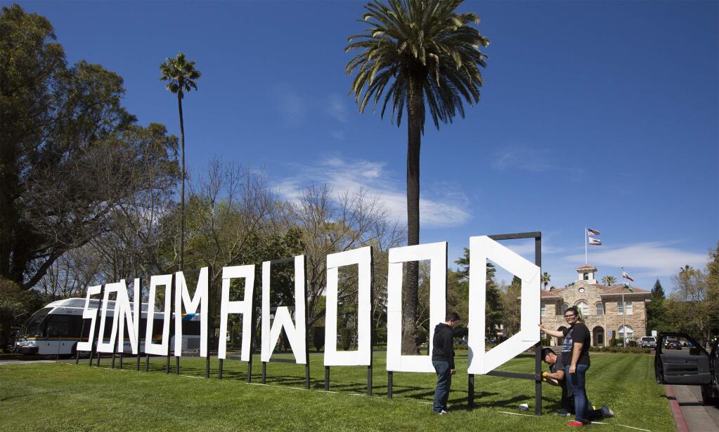 Putting up the SONOMAWOOD sign on the Plaza has come to represent the beginning of the Sonoma International Film Festival, which starts on Wednesday and runs through Sunday, April 2. The sign was constructed by Creekside High School students and, with a little help from teacher Walt Williams, Fernando Corona, 17, and Montse Salazar, 16, now welcomes festival goers to the five-day event. (Photo by Robbi Pengelly/Index-Tribune)