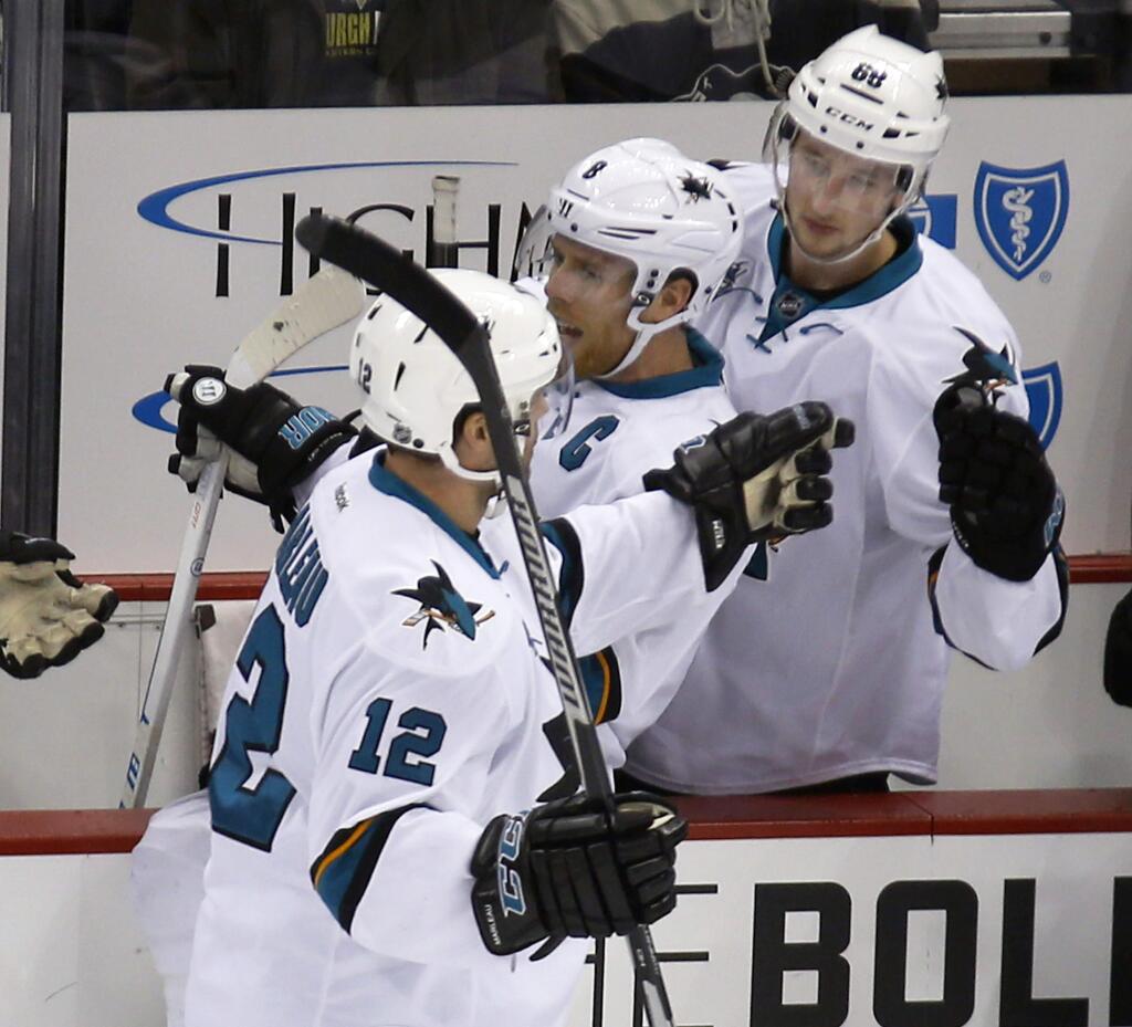 San Jose Sharks' Patrick Marleau (12) is greeted by teammates on the bench after getting an assist on a goal by Brent Burns for his 100th career point in the NHL in the first period, Saturday, Nov. 21, 2015, in Pittsburgh. (AP Photo/Keith Srakocic)