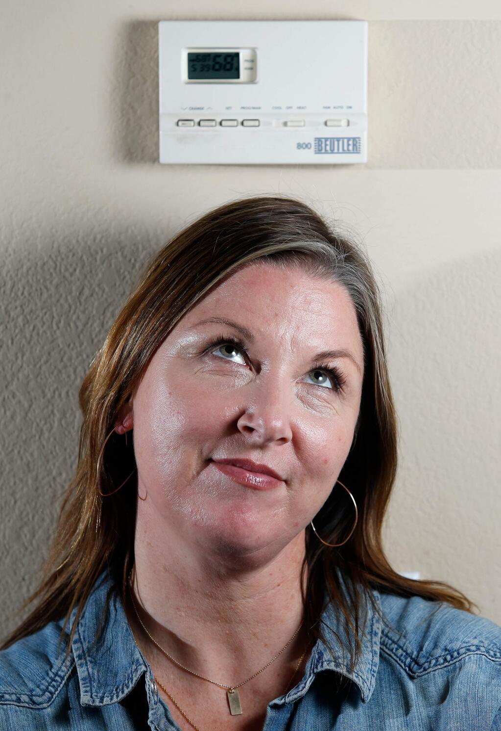 Nicole Reyes poses for a portrait beside the thermostat at her home in Petaluma, California on Wednesday, January 11, 2017. Reyes' home heating bill jumped over $200 since last November. (Alvin Jornada / The Press Democrat)