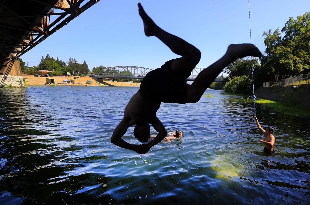 Ulysses Gonzalez of Santa Rosa dives into the Russian River in Healdsburg upriver of River's Edge Beach in July. (JOHN BURGESS/ PD FILE)