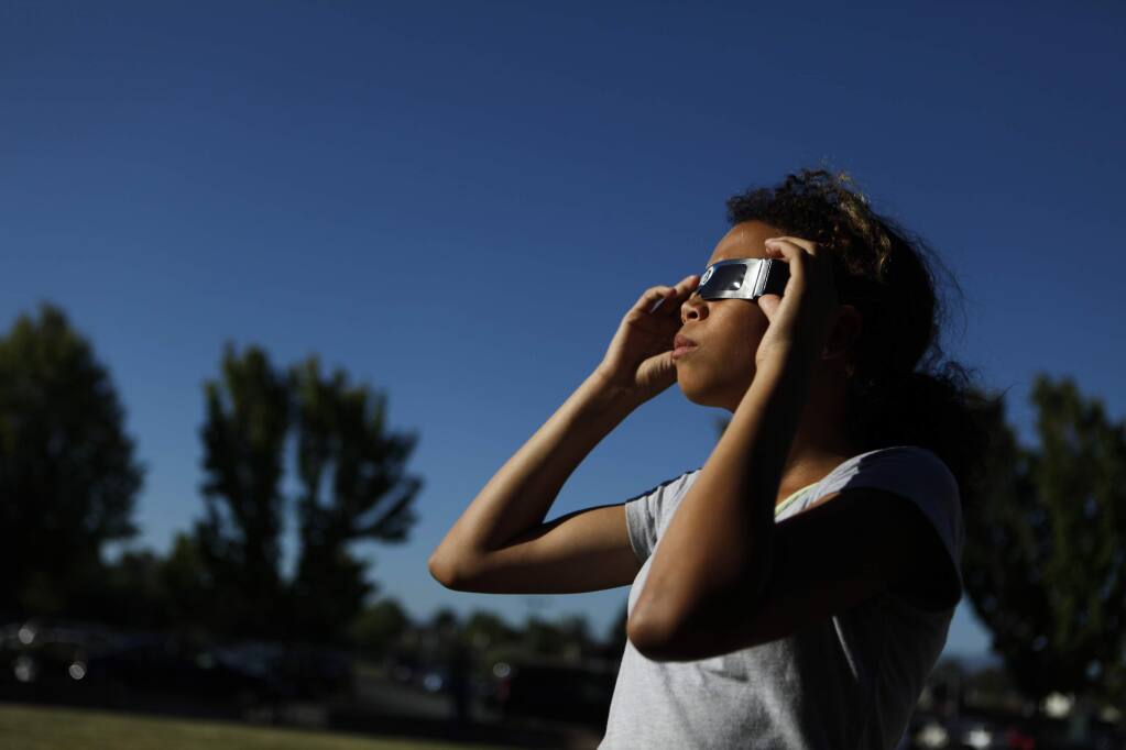 Kelsie Granneman, 12, watches a partial solar eclipse at Piner High School in Santa Rosa, on Sunday, May 20, 2012. (BETH SCHLANKER/ The Press Democrat)