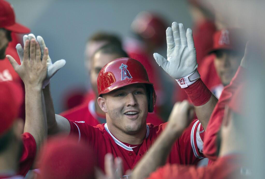 In this Sept. 3, 2016, file photo, the Los Angeles Angels' Mike Trout is congratulated by teammates after hitting a solo home run off Seattle Mariners starter Taijuan Walker during the first inning in Seattle. (AP Photo/Stephen Brashear, File)