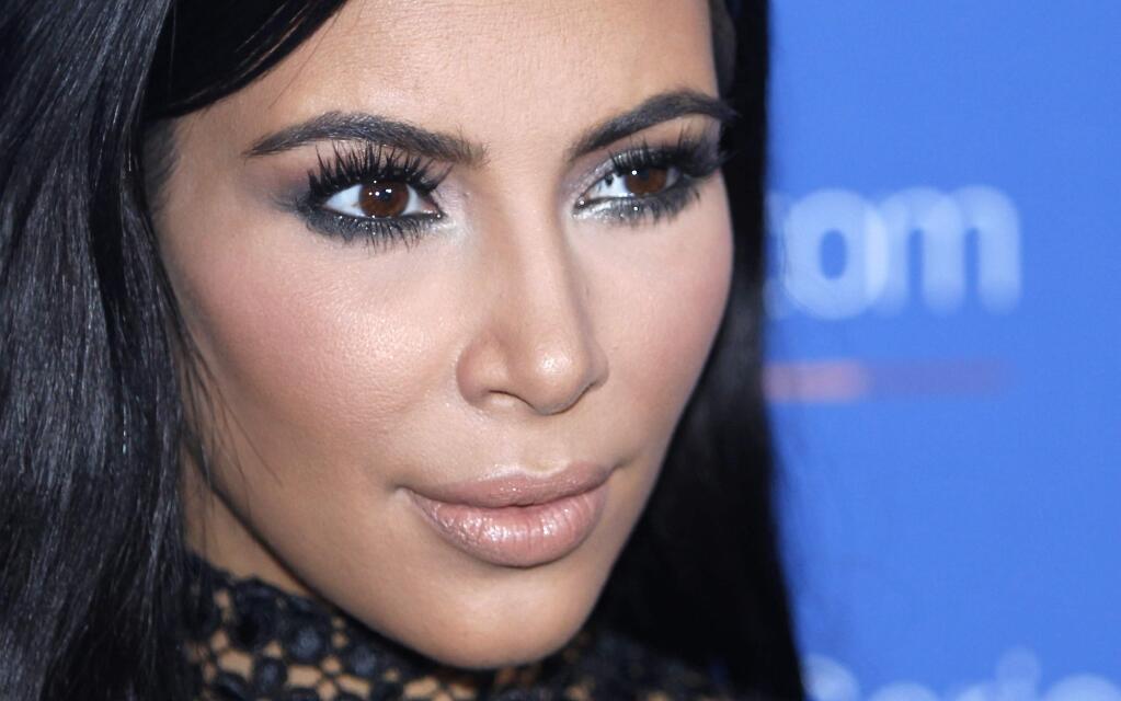 FILE - In this June 24, 2015, file photo, Kim Kardashian poses during a photo call at the Cannes Lions 2015. A spokeswoman for Kardashian West says she was held up at gunpoint inside her Paris hotel room Sunday, Oct. 2, 2016, by two armed masked men dressed as police officers. The representative said the reality TV star is 'badly shaken but physically unharmed.' She offered no other details. (AP Photo/Lionel Cironneau, File)
