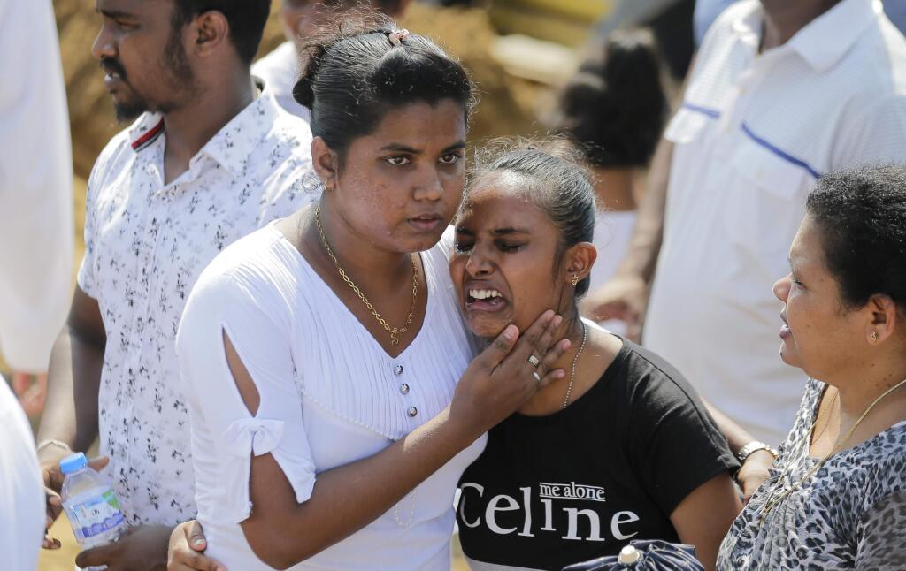 Family members of Sri Lanka's Easter Sunday church explosion mourn during a funeral in Katuwapitiya village in Negombo, Sri Lanka, Wednesday, April 24, 2019. Sri Lanka's president has asked for the resignations of the defense secretary and national police chief, a dramatic internal shake-up after security forces shrugged off intelligence reports warning of possible attacks before Easter bombings that killed over 350 people, the president's office said Wednesday. (AP Photo/Eranga Jayawardena) (AP Photo/Eranga Jayawardena)