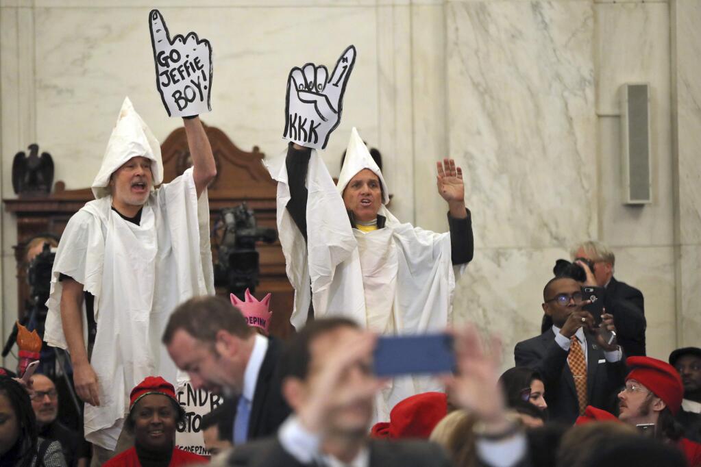 Demonstrators are seen on Capitol Hill in Washington, Tuesday, Jan. 10, 2017, during the Senate Judiciary Committee's confirmation hearing for Attorney General-designate, Sen. Jeff Sessions, R-Ala. (AP Photo/Andrew Harnik)