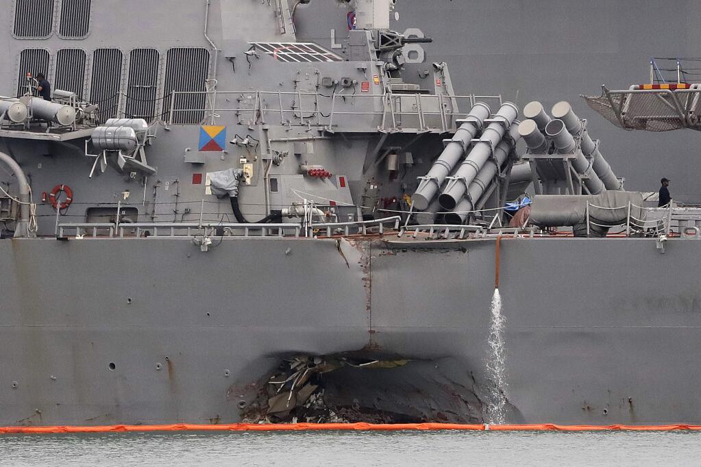 The damaged port aft hull of the USS John S. McCain, is visible while docked at Singapore's Changi naval base on Tuesday.. (WONG MAYE-E / Associated Press)
