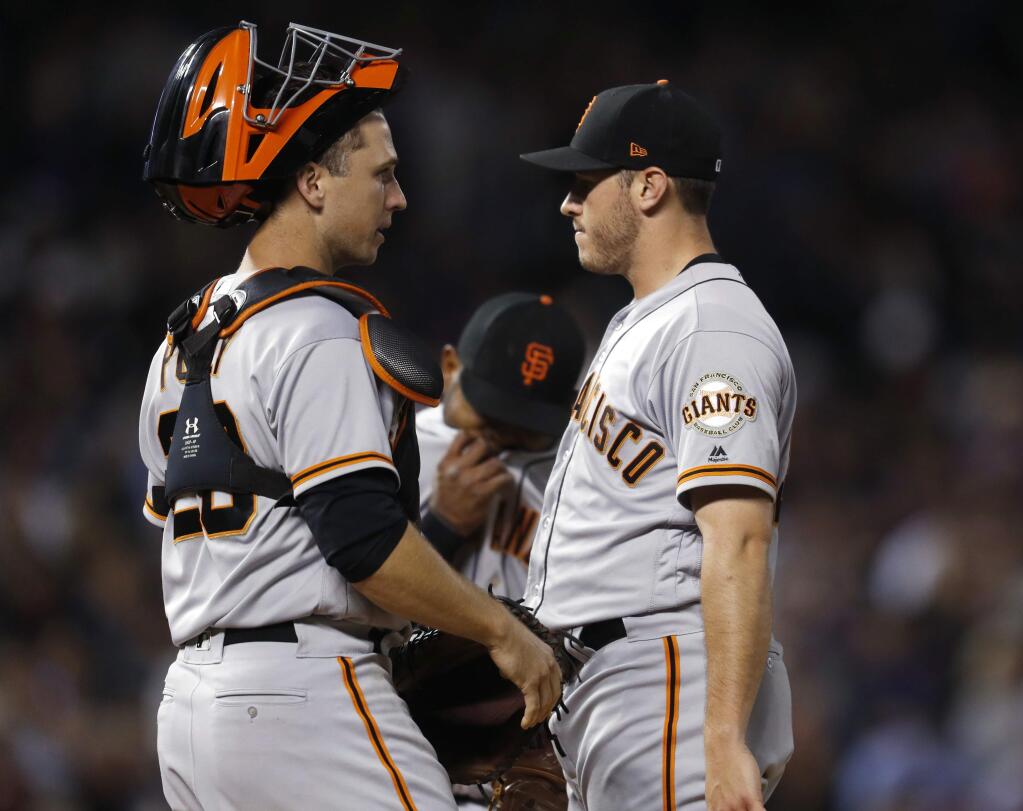 San Francisco Giants catcher Buster Posey, left, talks to starting pitcher Ty Blach, who waits to be removed from the mound after retiring Colorado Rockies' Gerardo Parra during the sixth inning of a baseball game Tuesday, Sept. 5, 2017, in Denver. Colorado won 9-6. (AP Photo/David Zalubowski)