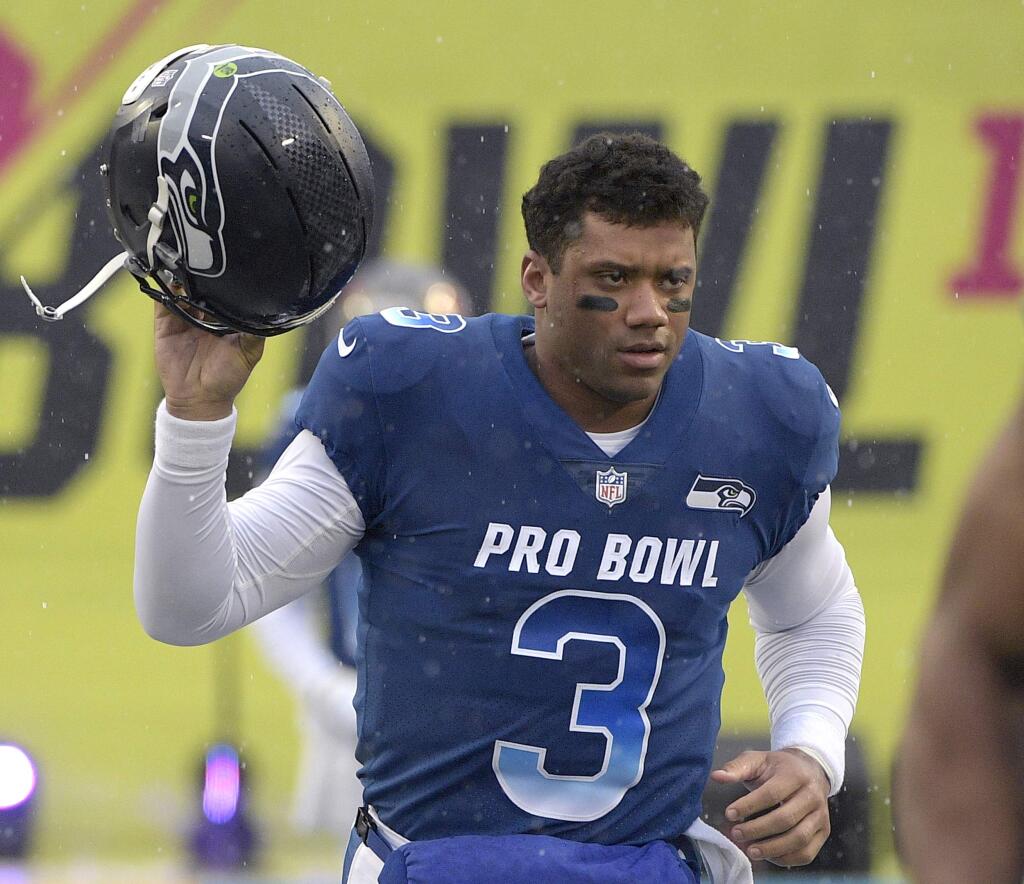 FILE - In this Jan. 27, 2019, file photo, NFC quarterback Russell Wilson of the Seattle Seahawks runs onto the field during player introductions before the NFL Pro Bowl football game against the AFC in Orlando, Fla. Wilson posted a video to social media early Tuesday, Apriil 16, 2019, saying, 'Seattle, we got a deal,' shortly after a reported midnight deadline for the Seahawks and their star quarterback to agree on a contract extension. Wilson's current $87.6 million, four-year deal was signed at the beginning of training camp in 2015 and was set to expire after next season. (AP Photo/Phelan M. Ebenhack, File)